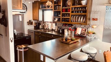 A modern kitchen with a central island, stainless steel appliances, and wooden cabinetry.