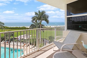 A balcony with a view of a swimming pool, beach, and ocean. - Beachfront-Pool-Fort Myers Beach(our Pool is open) (Fort Myers Beach)