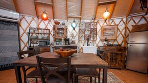 Una cocina acogedora con muebles de madera, una mesa de comedor y lámparas colgantes.