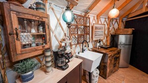 Una cocina rústica con armarios de madera, un lavamanos y una cafetera.