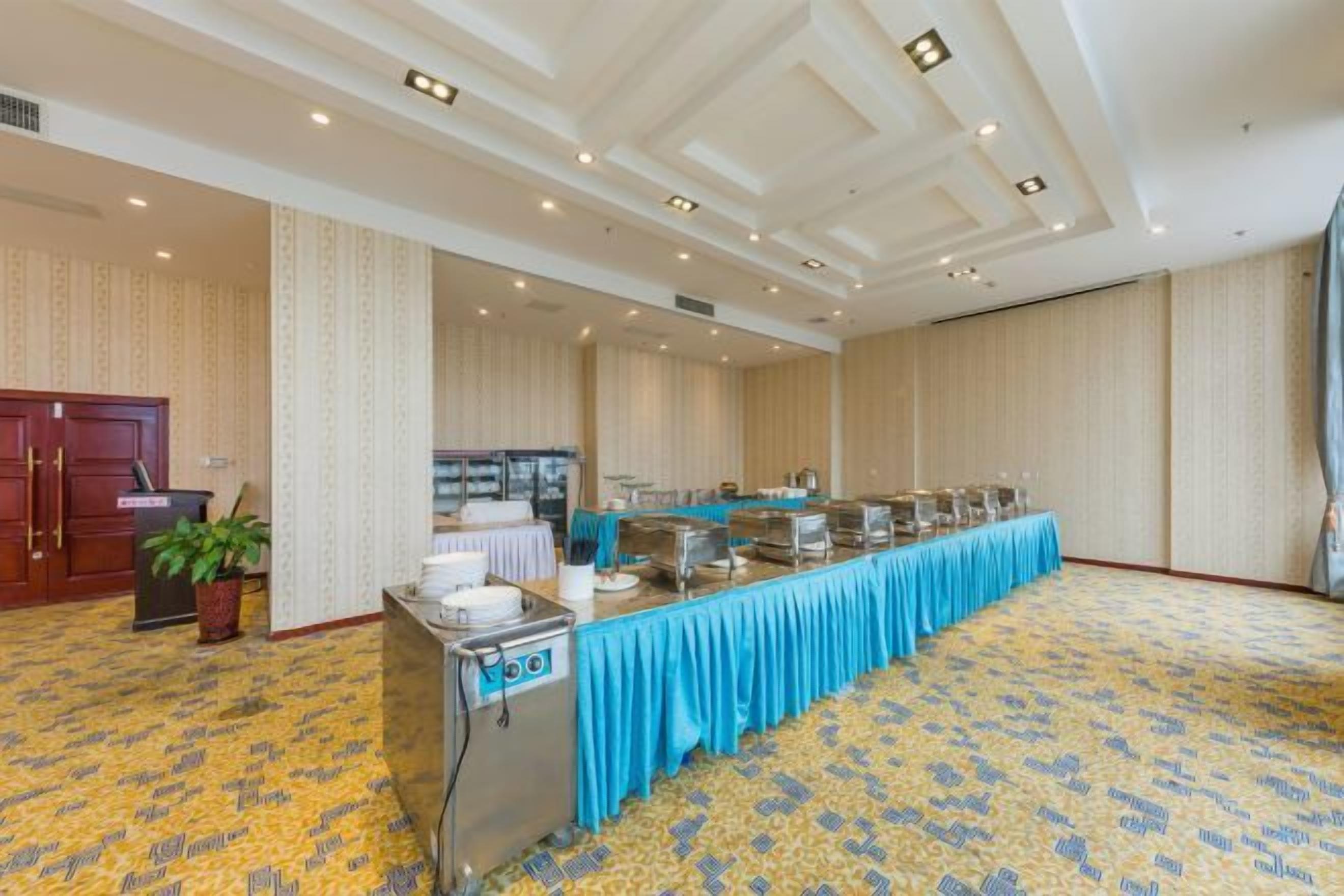 A conference room with a long table, a podium, and a buffet setup.