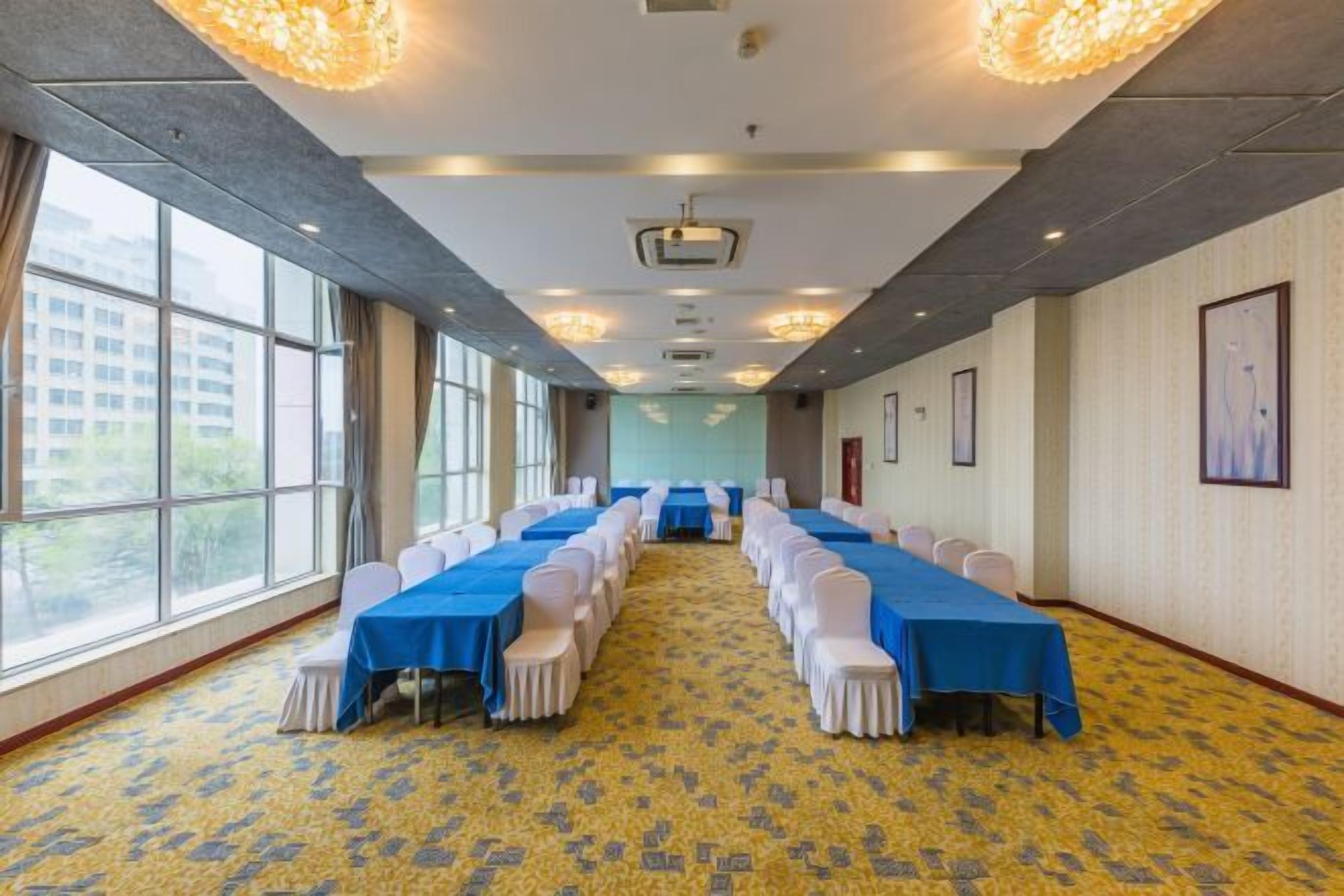 Uma sala de conferências com uma mesa comprida, cadeiras e piso coberto de carpete.