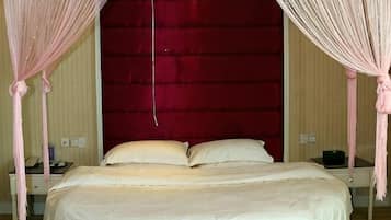 A bed with a canopy, a nightstand, and a red headboard.