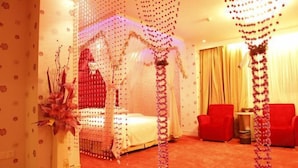 A room with a canopy bed, red chairs, and a red carpet.