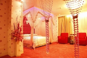 A room with a canopy bed, red chairs, and a red carpet.