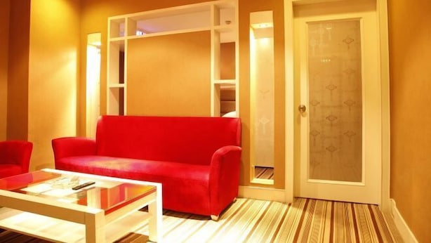 A room with a red sofa, a white coffee table, and a door with a frosted glass panel.