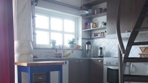 A kitchen with a wooden floor, a white stove, and a blue table.