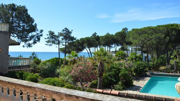 A pool area with a view of the sea, surrounded by lush greenery and a stone building. - Un Balcon sur la Méditerranée 1 (Taglio-Isolaccio)