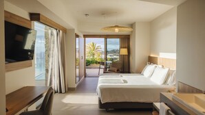 Une chambre d’hôtel comprenant un lit, un bureau, une chaise, une télévision, une lampe et une salle de bain avec une baignoire.