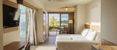 A hotel room with a bed, a desk, a chair, a TV, a lamp, and a bathroom with a bathtub.