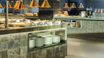 A buffet area with a marble counter, multiple serving stations, and overhead pendant lighting.