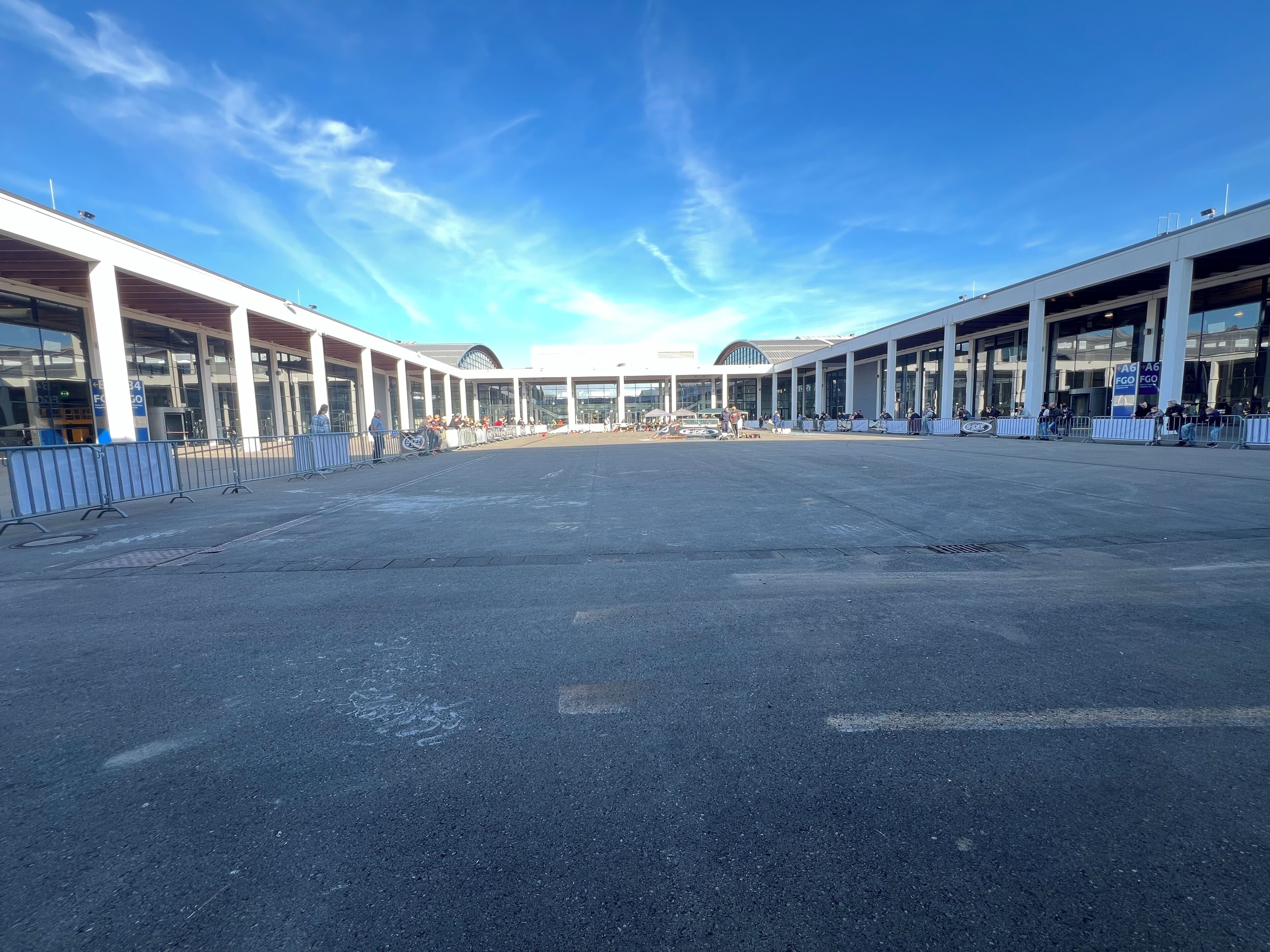 Un'ampia sala terminal dell'aeroporto con grandi finestre e cielo sereno.