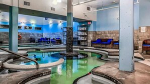 A pool area with multiple hot tubs, seating areas, and a central column. - NEW!The Nizza by SSR|TOP Luxur&View|1350SQF|2BR+2BTH ( BL# RES-11742 ) (Canmore)