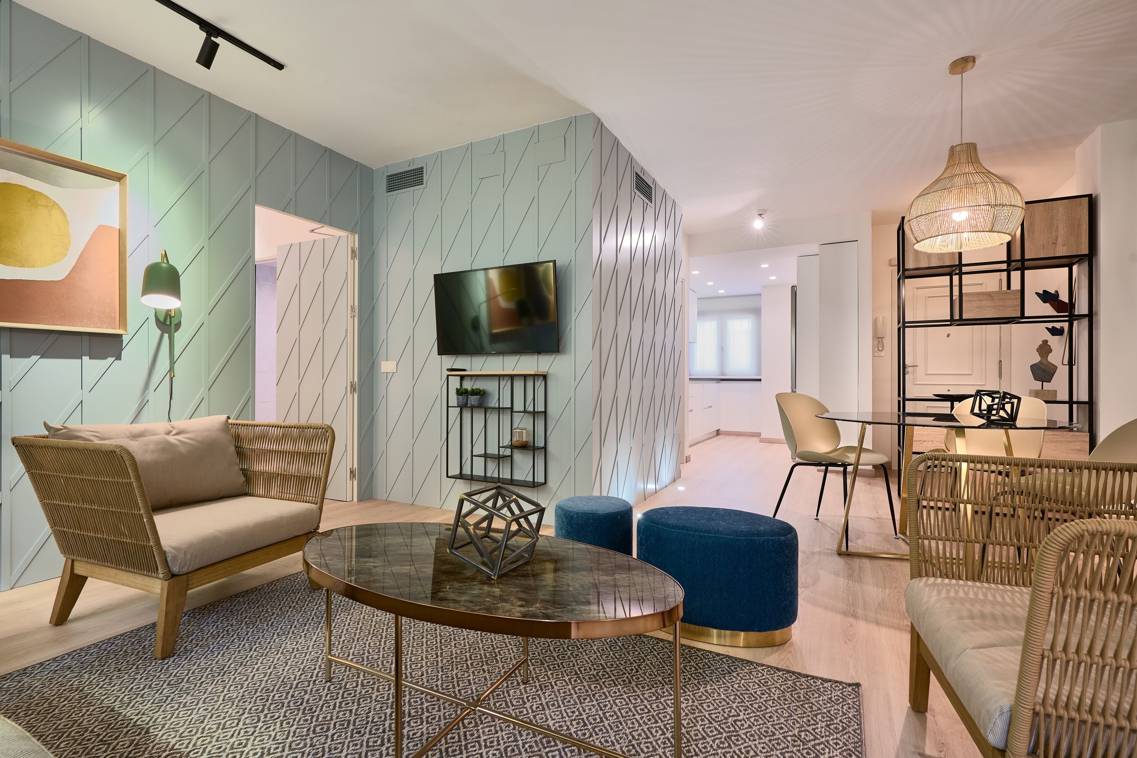 A modern living room with a sofa, a round coffee table, and a television.