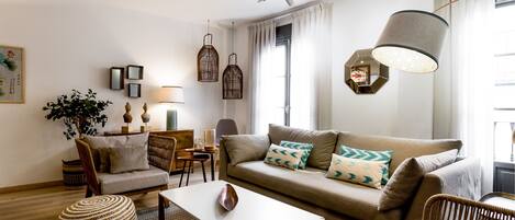 Un salon moderne comprenant un canapé, des fauteuils, une table basse et des objets de décoration.