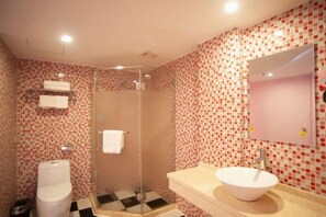 A bathroom with a tiled shower, a toilet, and a sink with a mirror. - Impression Lijiang Hotel (Guilin)