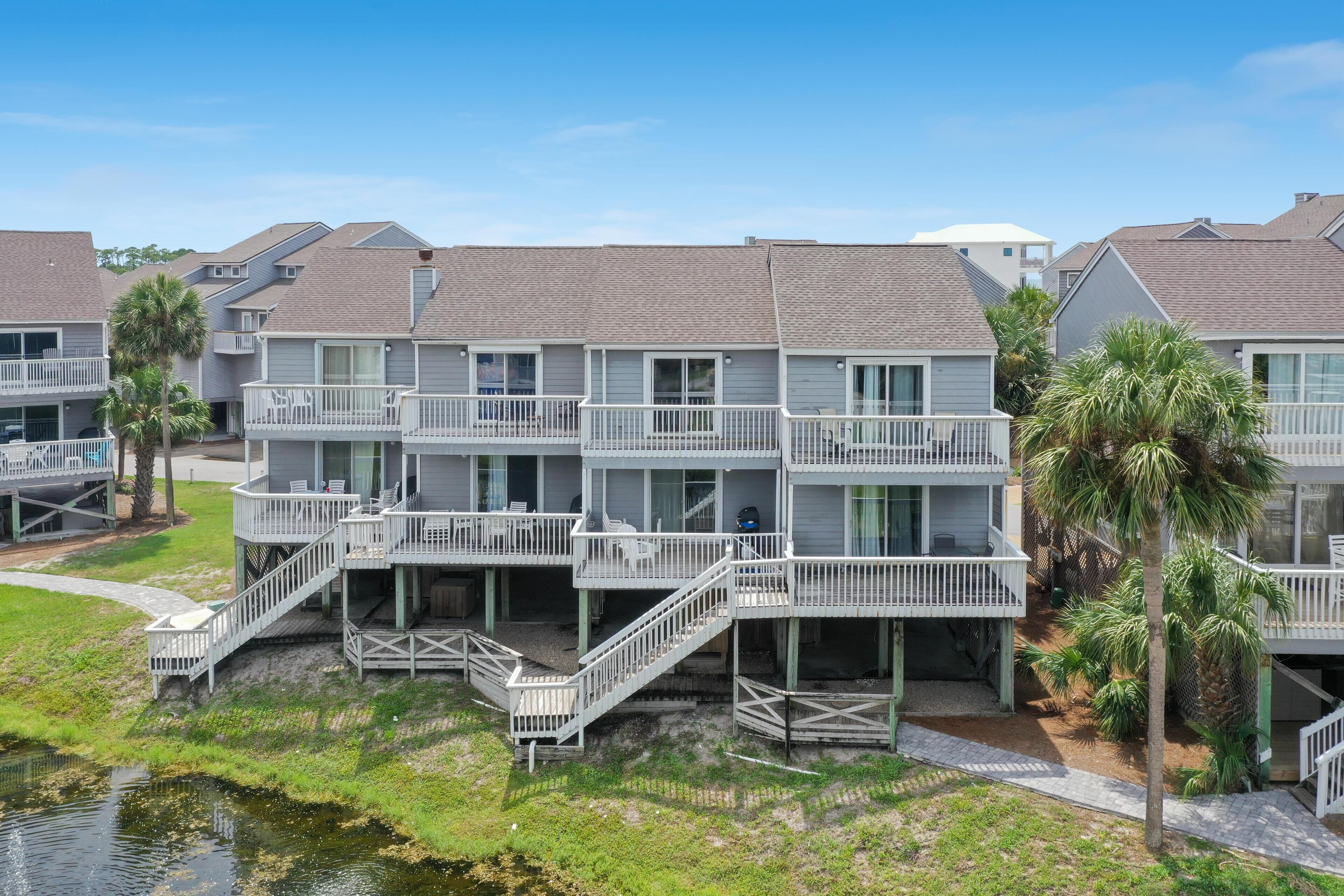 A beachfront hotel with multiple balconies, a pool, and a view of the ocean.