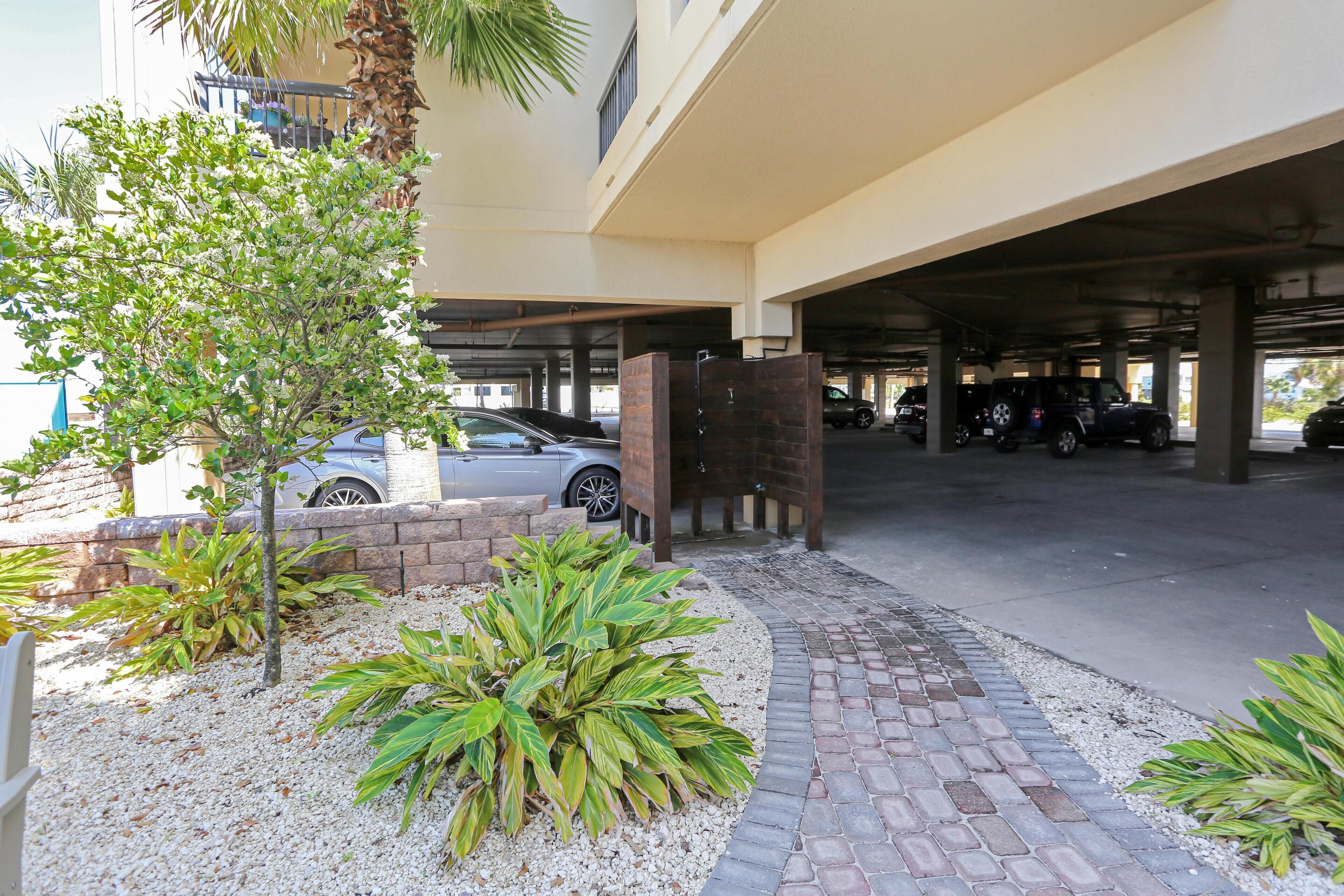 A parking garage entrance with a brick pathway leading to a gated driveway.