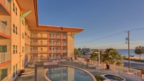 A hotel with a pool area, outdoor seating, and a view of the beach. - Paradise Shores 403 Sunset Paradise (Port St. Joe)