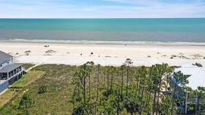A beach view with a house and a boat. - Seas of Jade (Port St. Joe)