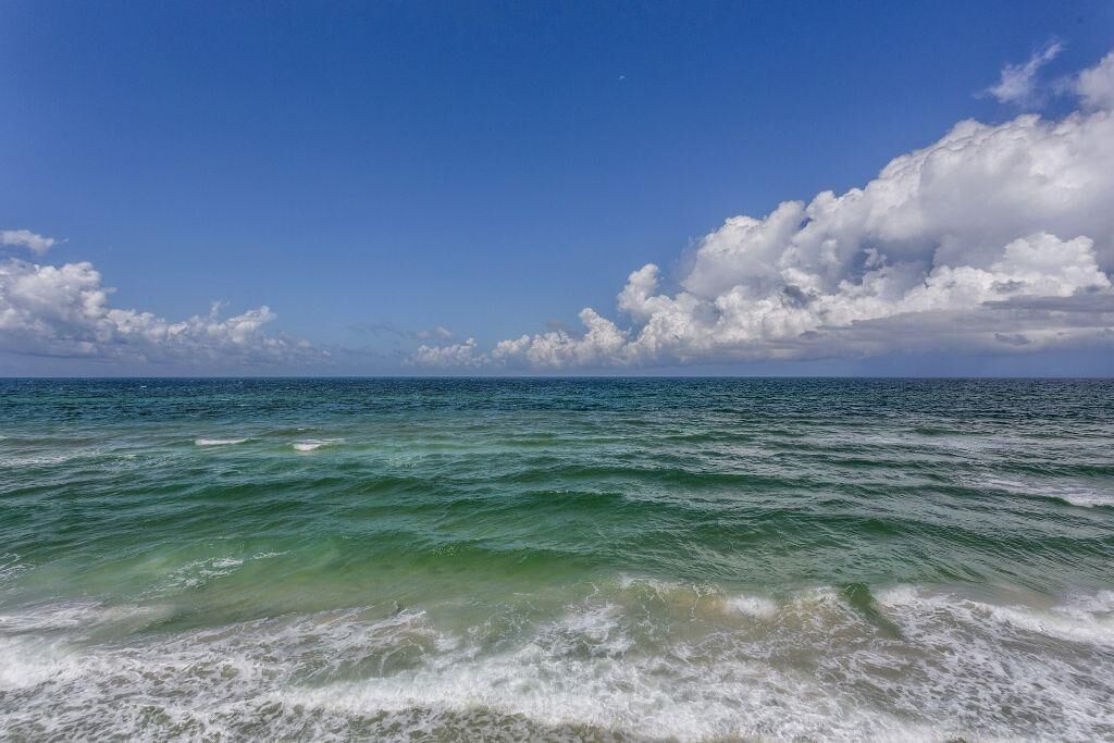 A view of the ocean with waves and a clear sky.