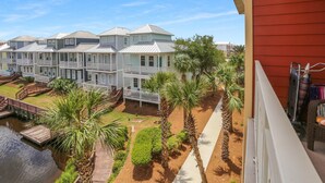 A row of townhouses with a shared dock and palm trees.