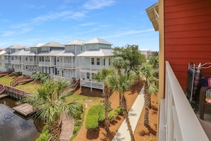 A row of townhouses with a shared dock and palm trees.