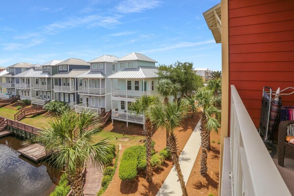 A row of townhouses with a shared dock and palm trees. - Waterside Village Condo 302 (Port St. Joe)