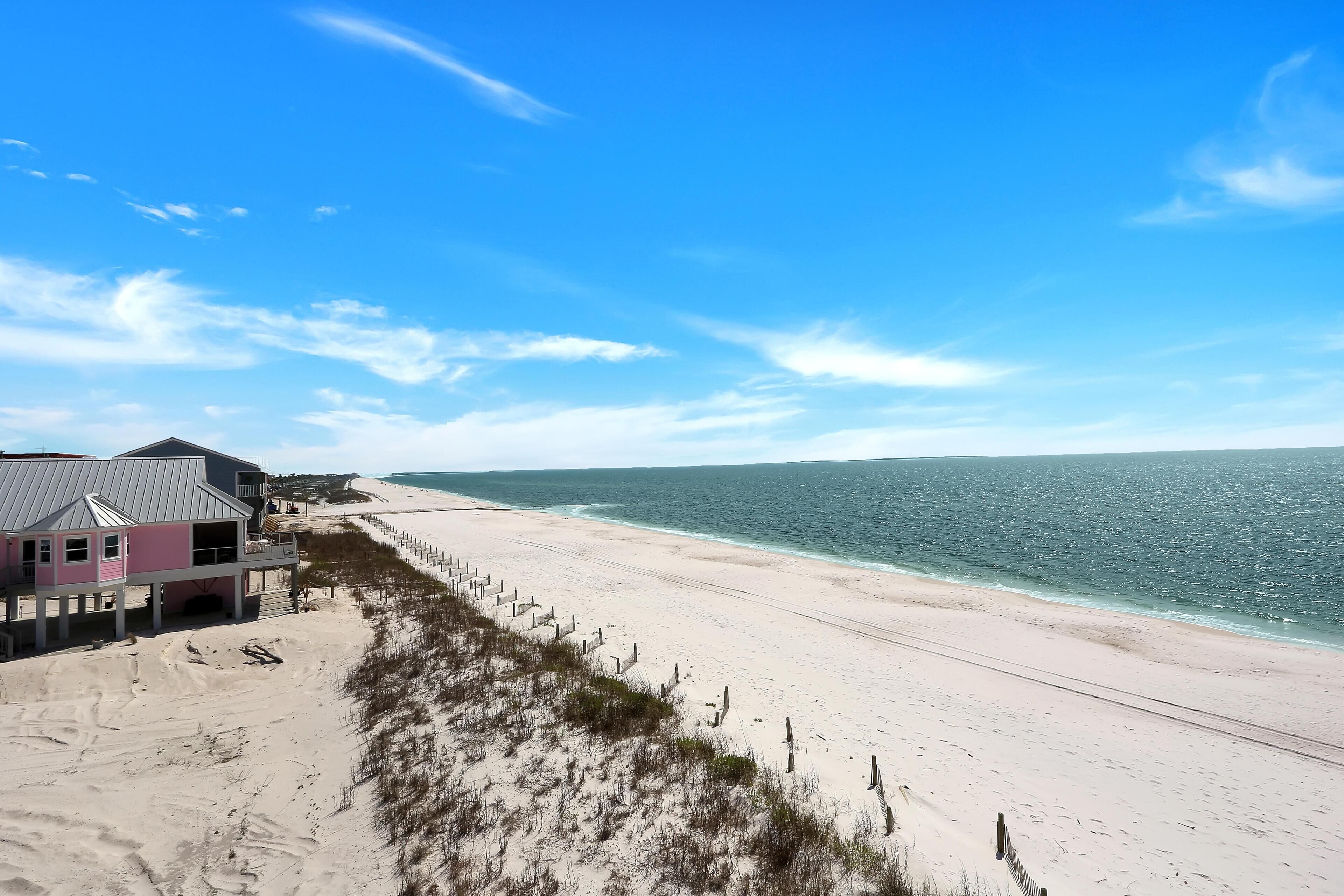 Ein Strandhaus mit Balkon mit Blick auf den Ozean.