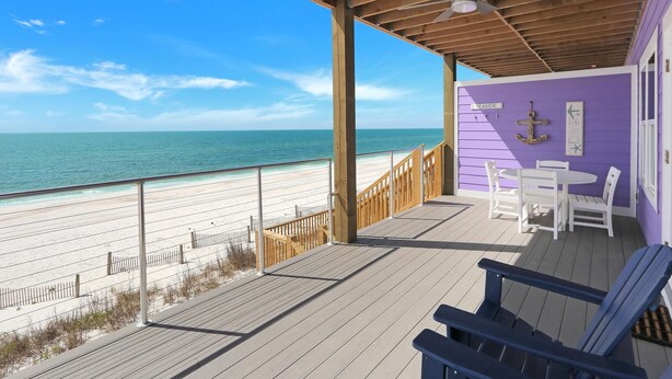A wooden deck with a view of the beach, a purple wall with an anchor decoration, and a sign reading "Seaside." - Beach Fantasies A (Port St. Joe)