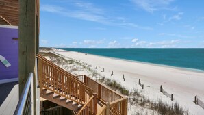 A wooden staircase leading to a beach with a clear view of the ocean. - Beach Fantasies B (Port St. Joe)