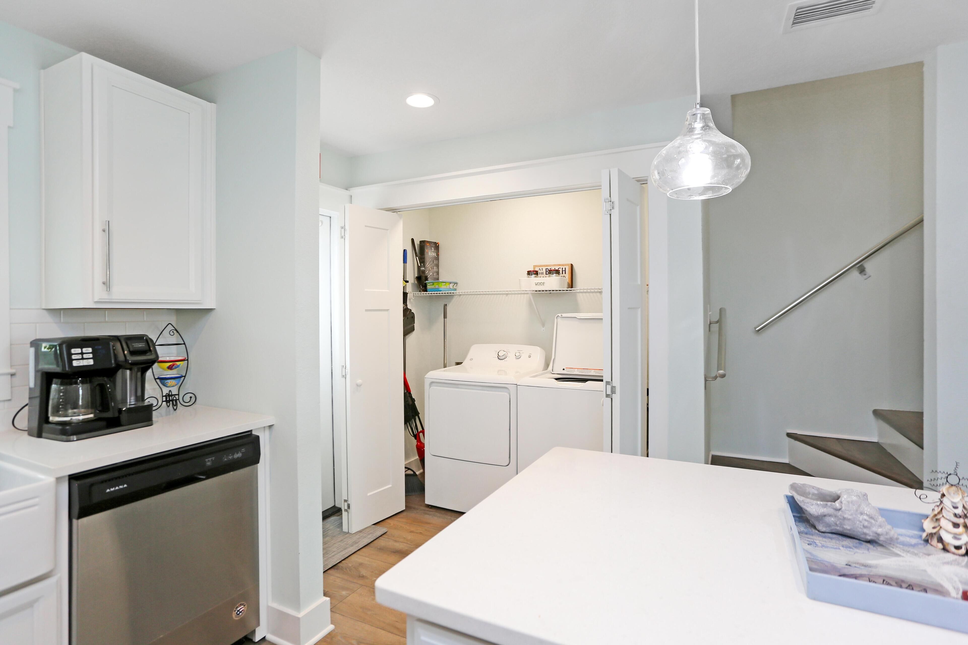 A compact kitchen with a dishwasher, a coffee maker, and a washing machine.