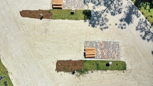 An aerial view of a park with two picnic areas, each with benches and a paved surface. - Bay Destiny RV Lot 2 (Port St. Joe)