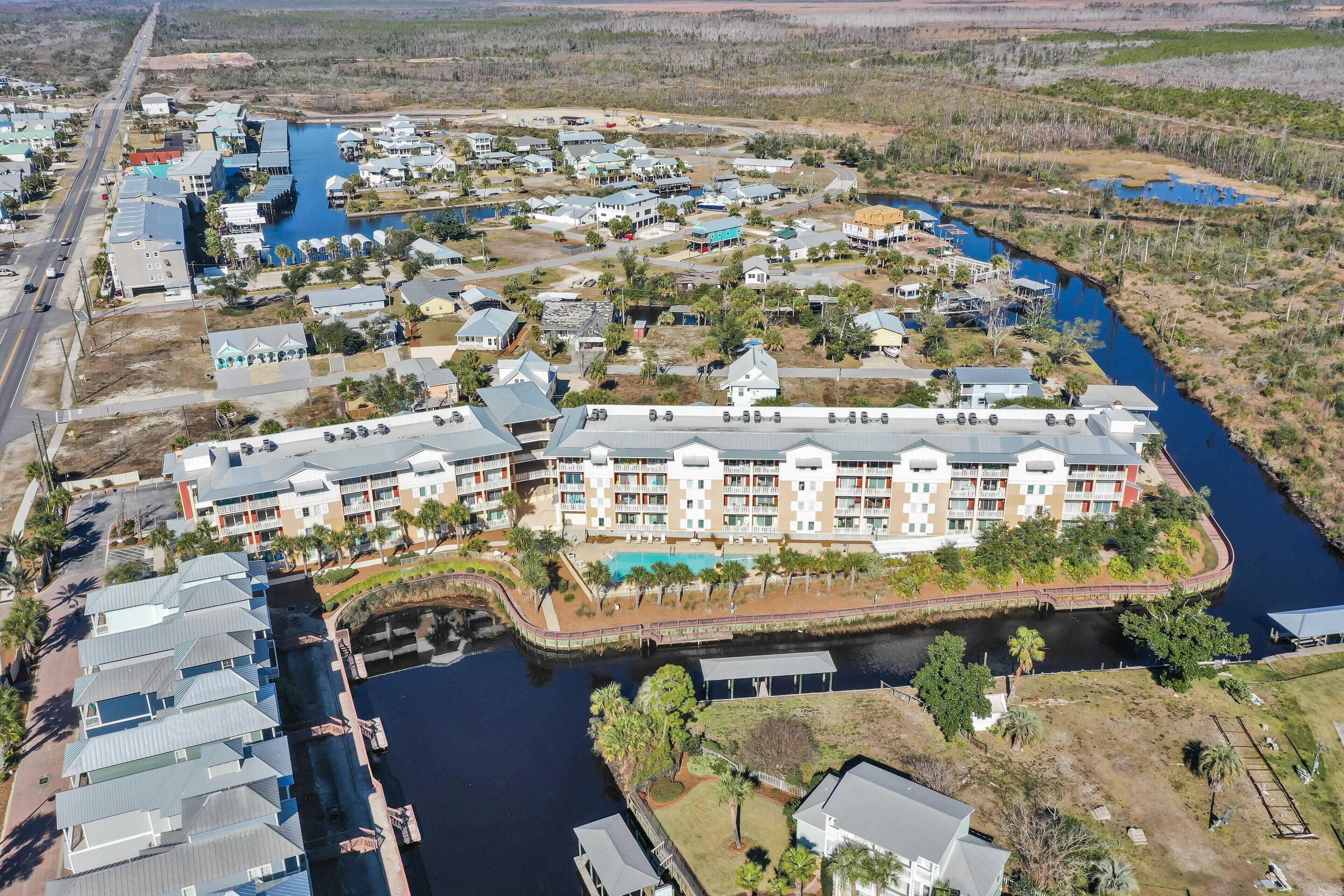 Luchtbeeld van een resort met meerdere gebouwen, een jachthaven en een rivier.