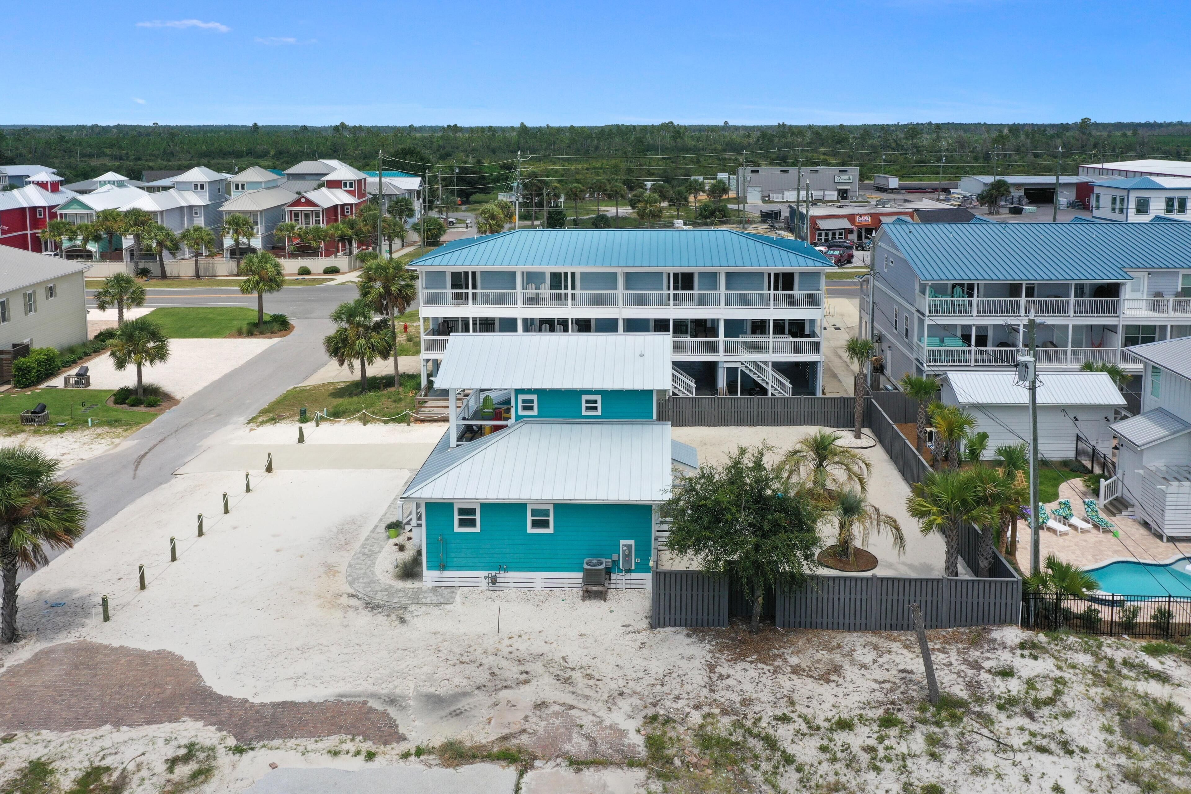 Et kysthotel med en blå bygning, pool og en strand.