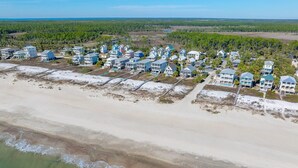 An aerial view of a coastal residential area with beachfront properties, including houses with balconies and a beach in the foreground. - Eagle's Rest (Port St. Joe)