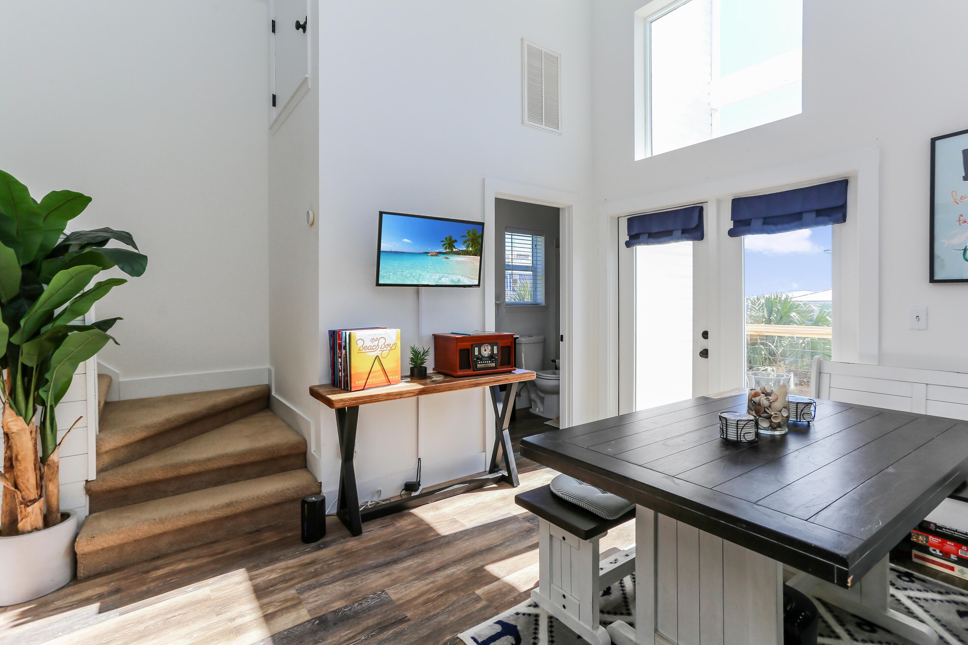 A modern kitchen with a dark wooden table, a built-in bench, and a view of the outdoors.