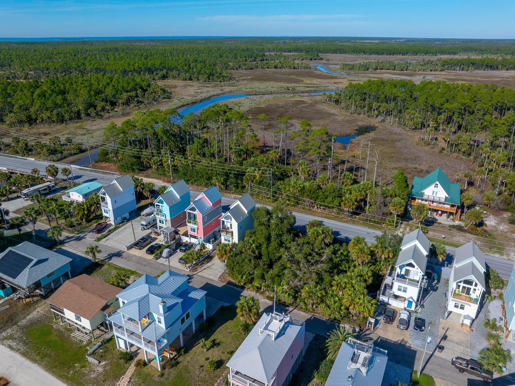 Vue aérienne d’un quartier résidentiel avec des maisons, une route et une rivière.