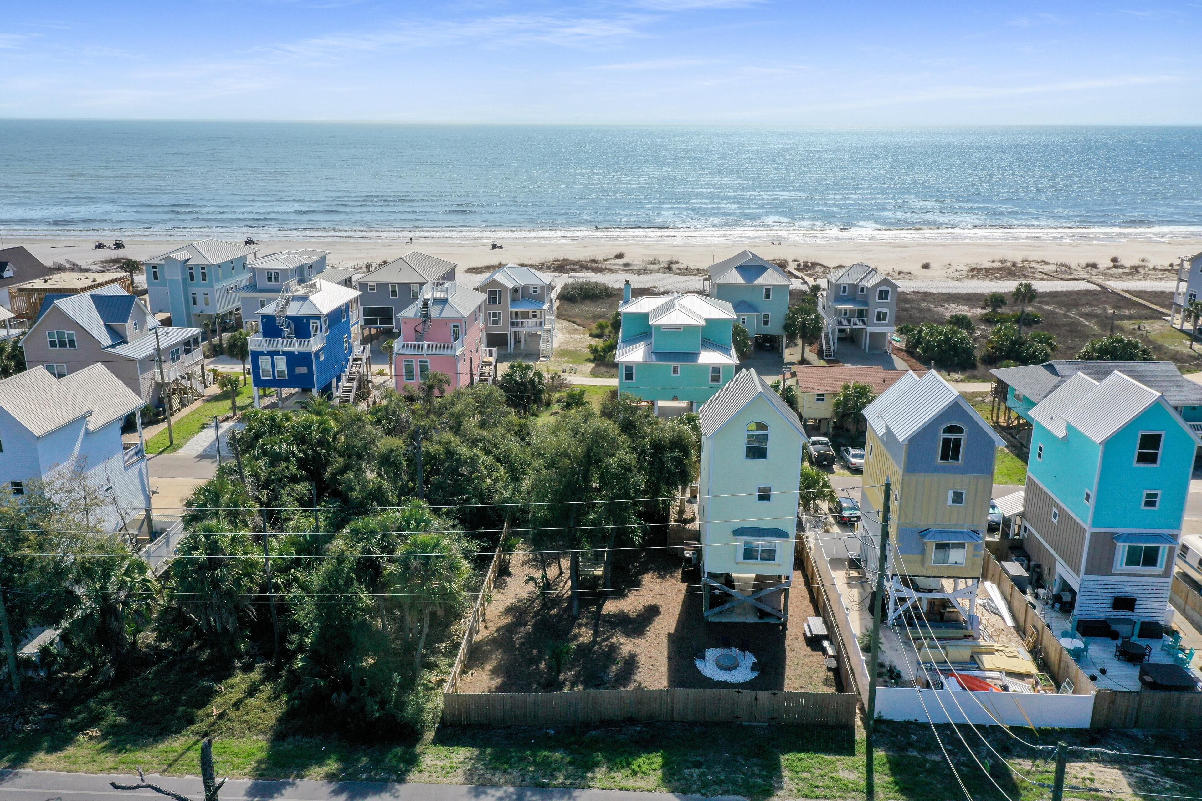 Un quartier résidentiel situé sur la côte, avec des maisons à proximité de la plage, caractérisé par un mélange de bâtiments à un ou plusieurs étages, dont certains sont dotés de terrasses et de patios apparents.