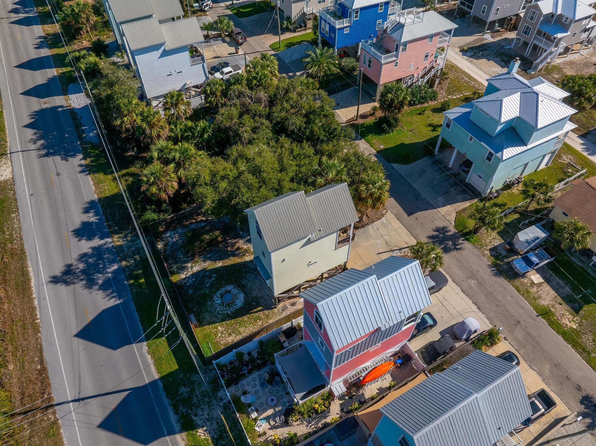 An aerial view of a residential area with houses, roads, and greenery.