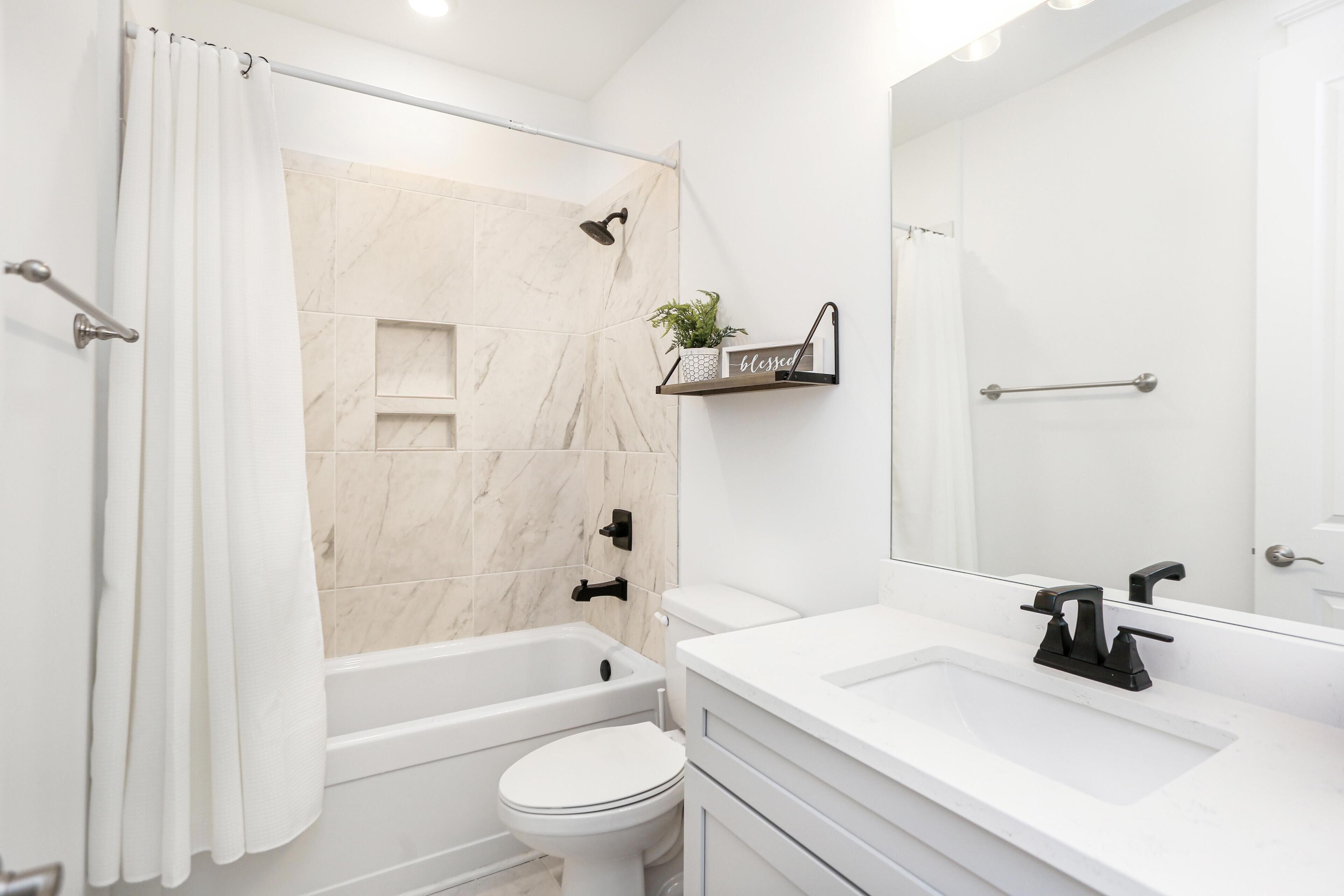 A modern bathroom with a bathtub, toilet, and sink.