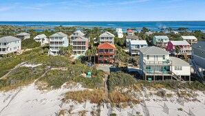 A coastal residential area with multiple houses, some with balconies, and a beach in the background. - Sea Joy (Port St. Joe)