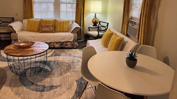 Un salon chaleureux avec un canapé, une table basse ronde et une petite table avec une lampe.