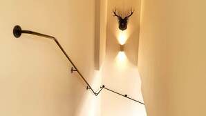 Eine Treppe mit einer Wandleuchte in Form eines Geweihs am oberen Ende.