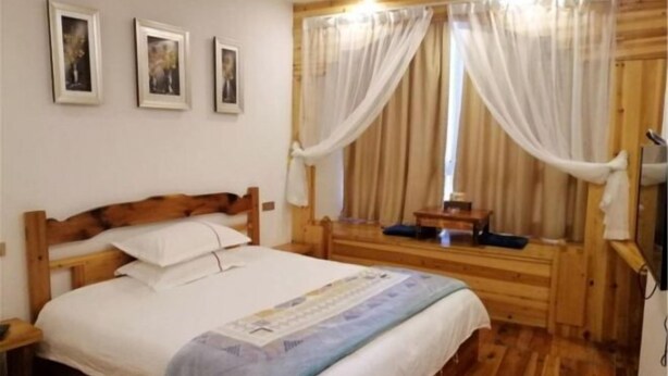 A wooden-framed room with a bed, curtains, and framed pictures on the wall. - Lake House (Taishun)