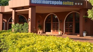Hotel Marcopolo Suites with a covered entrance, arched windows, and a landscaped garden area. - Marcopolo Inn Iguazu (Puerto Iguazú)