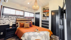 A bedroom with a bed, a nightstand, a dresser, a chandelier, and a window with blinds. - Panoramic Porch View Close to Town @ Casa Pequena (Alpine)