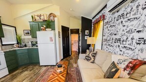 A compact living space with a kitchen, a sofa, and a coffee table. - Panoramic Porch View Close to Town @ Casa Pequena (Alpine)