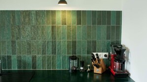 A kitchen with green tiles, a coffee machine, and a knife block. - Air-conditioned apartment with balcony - Deidesheim (Deidesheim)