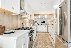 Een moderne keuken met witte kasten, roestvrijstalen apparatuur en een centraal eiland.